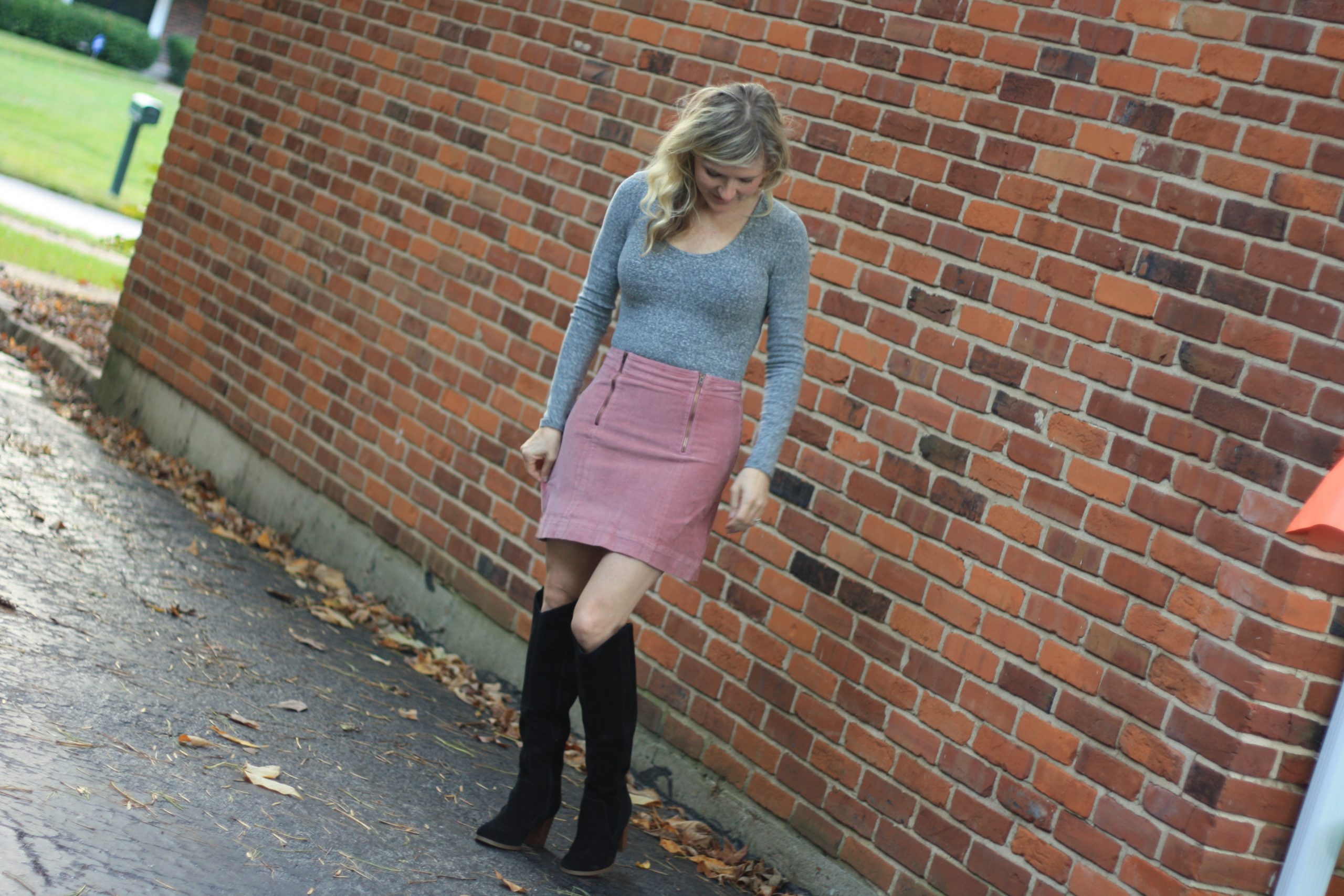 Madewell bodysuit featured by top US fashion blogger, Emmy Lou Styles: image of a woman wearing a grey Madewell bodysuit, a pink skirt and Sole Society boots