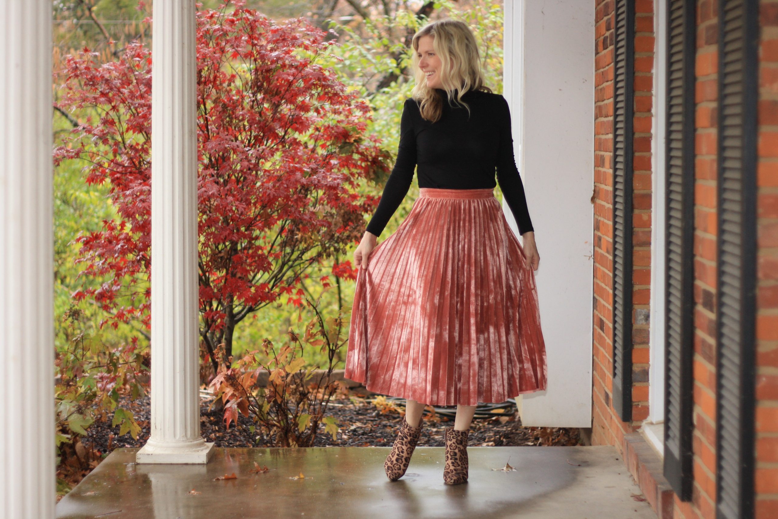 top 3 festive holiday outfits featured by top Missouri fashion blogger, Emmy Lou Styles: image of a blonde woman wearing a red velvet skirt and black turtleneck