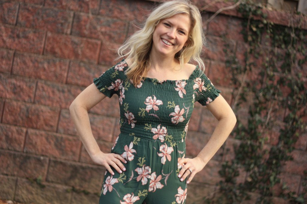 flowy green floral women's jumpsuit | 3 Jumpsuit styling tips featured by top US fashion blogger, Emmy Lou Styles: image of a blonde woman wearing a floral off the shoulder jumpsuit