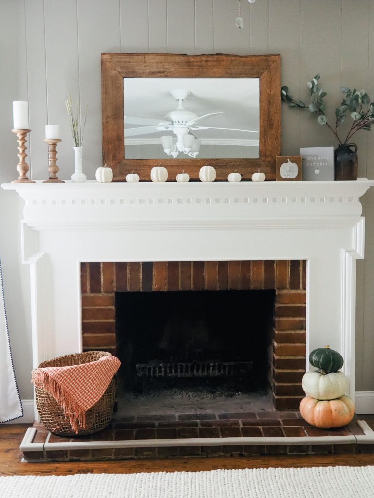 A simple mantle for fall featuring white pumpkins