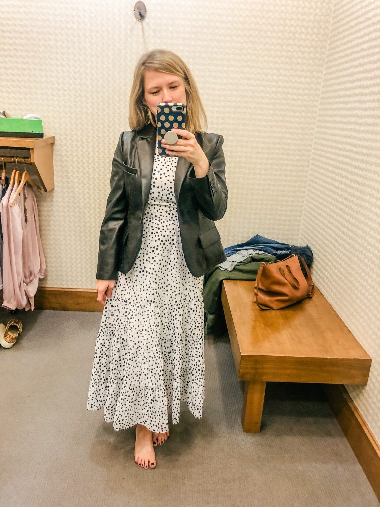 Photo of woman wearing white dress with polka dots and black leather blazer